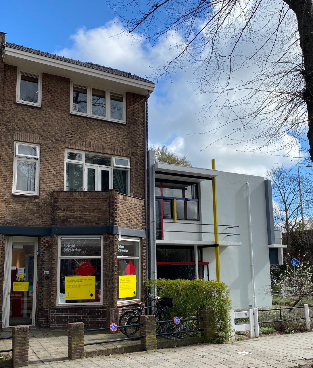 Dit huis is tegenwoordig het ticket office van het Rietveld Schröderhuis. Op de ruiten van het huis, zitten grote gele stickers met informatie, daarboven staat de tekst: 'Rietveld Schröderhuis'.