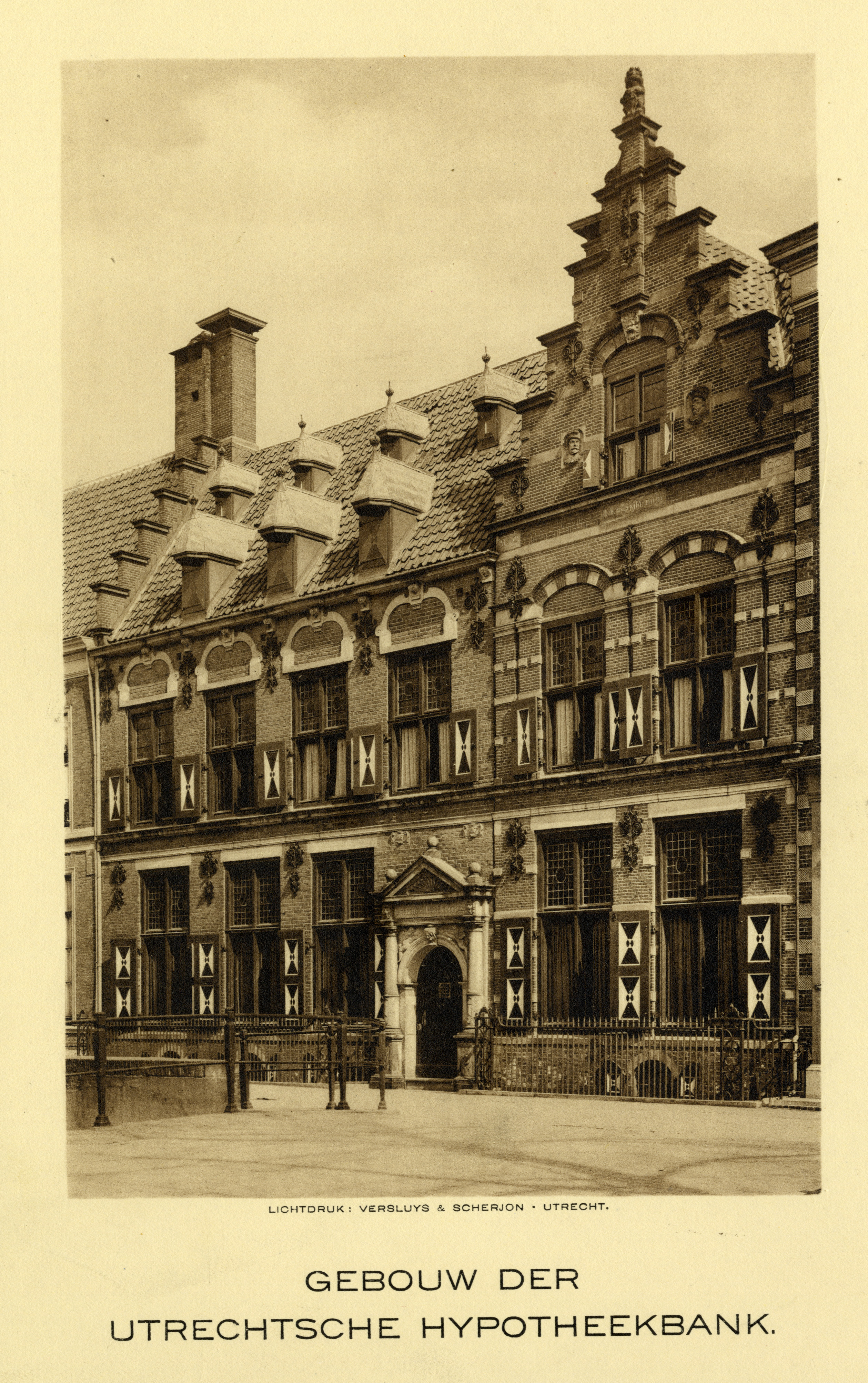 Een gebouw uit 1590 met luiken bij de ramen. Onder de foto staat ‘Gebouw Der Utrechtsche hypotheekbank.’ 